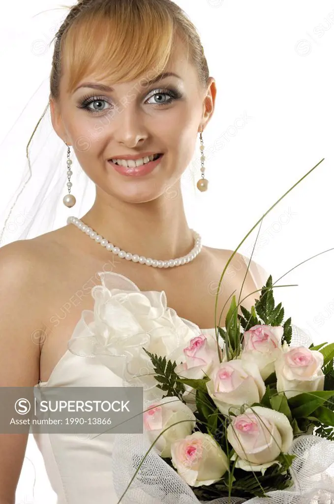 Stock photo of a Young beautiful smiling happy bride with a bunch of white roses Attractive woman in a wedding dress artistic portrait Twenty year old...