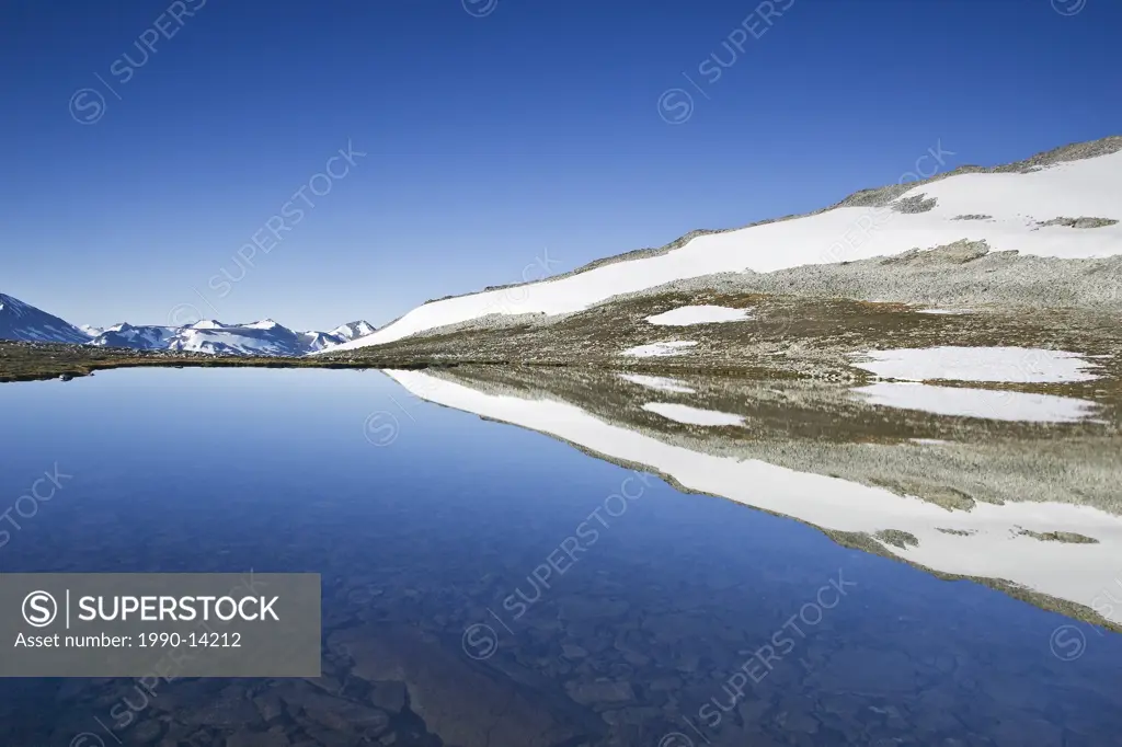 Alpine lake at dawn with reflections and Coast Mountains in the Chilcotin region of British Columbia, Canada