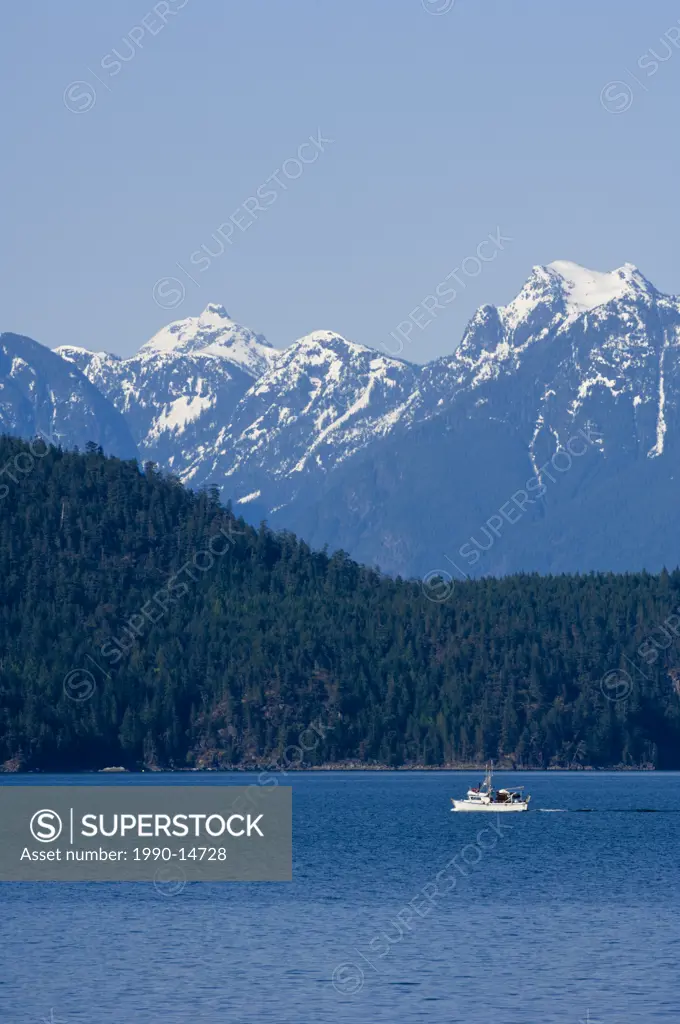 View eastward from Cortes Island to Coast Range mountains with small fishing boat in the distance, British Columbia, Canada