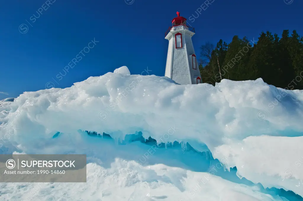 Lighthouse in winter at edge of Georgian Bay in Tobermory, Bruce Peninsula National Park, Ontario, Canada