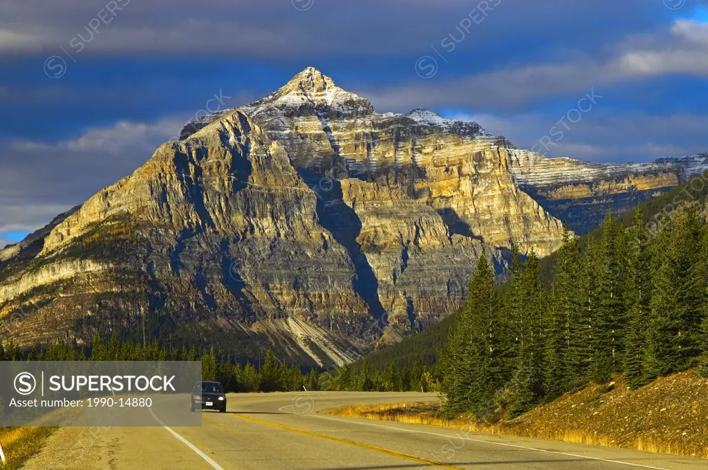 Single car on road with Mt. Whymper in background, Kootenay National Park, British Columbia, Canada