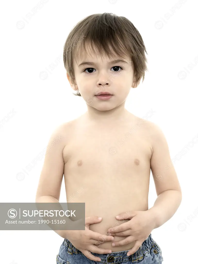 Two and half year old boy wearing jeans and no shirt against a white background