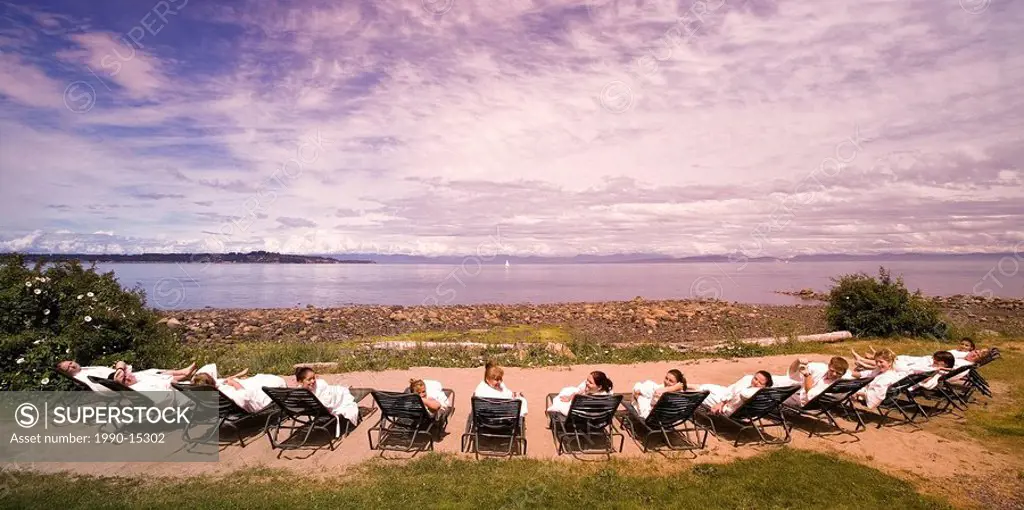 Spa enthusiasts relax on recliners overlooking Georgia Strait, Comox Valley, Vancouver Island, British Columbia, Canada