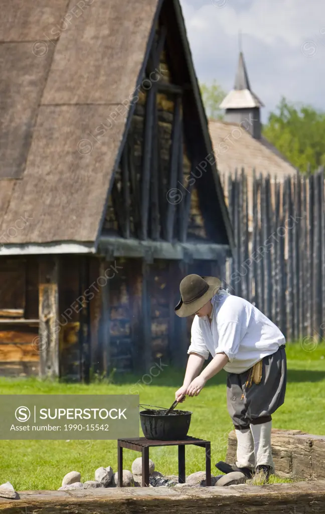 Costumed character tending a pot over a fire in the Sainte_Marie Among the Hurons settlement in the town of Midland, Ontario, Canada