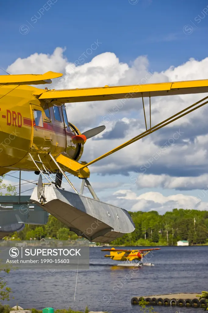 Norseman aircraft on a pedestal in the Norseman Heritage Centre Park with an active Norseman, Chimo Air Service, taxiing into the town of Red Lake, On...