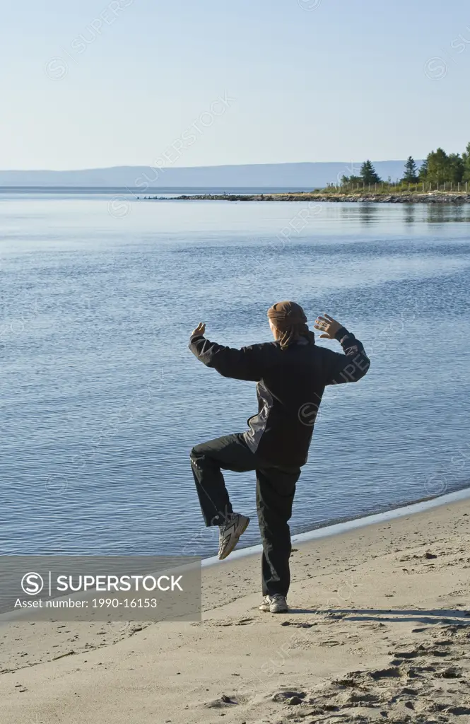 Person practising Tai_chi early in the morning on Cap_aux_Oies beach in Charlevoix, Quebec, Canada