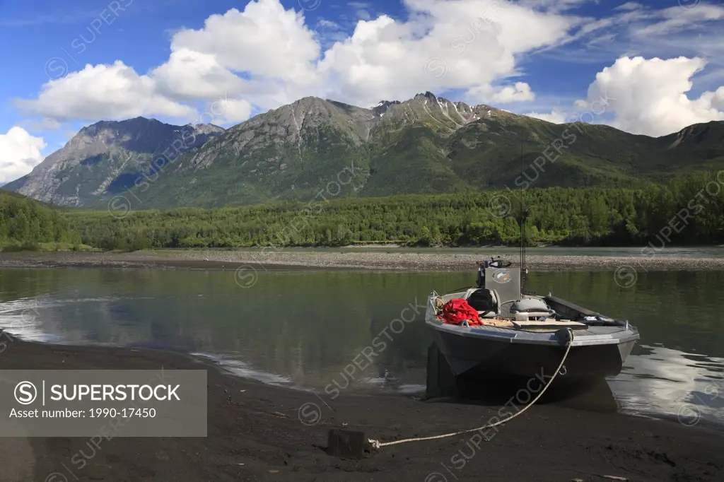 Boat in side channel of Skeena river near Hazelton, British Columbia. The Rocher deBoule mountain range in the background.