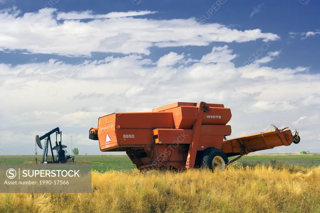Harvester and pumpjack, Hayes, Alberta, Canada, agriculture, farm machinery, oil, energy