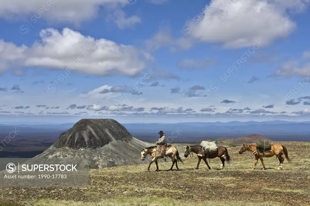 trail rider overlooking Volcanic cone in the Itcha Mountains in the Chilcotin region of British Columbia Canada