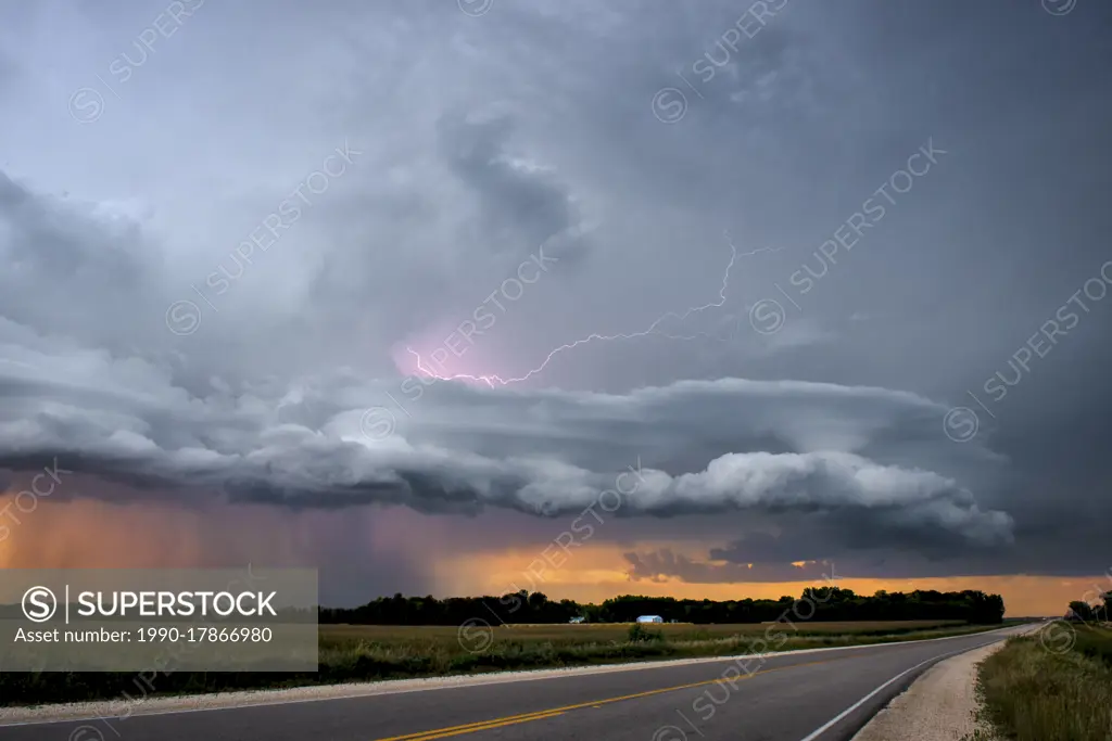 Lightning strikes with lenticular clouds over highway in rural southern Manitoba Canada