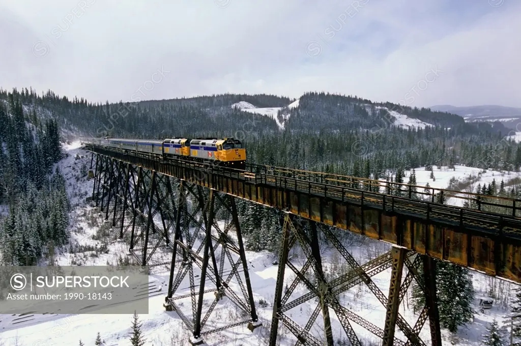 A Via Rail passenger train crossing a steel tressel in the foothills of Alberta Canada.