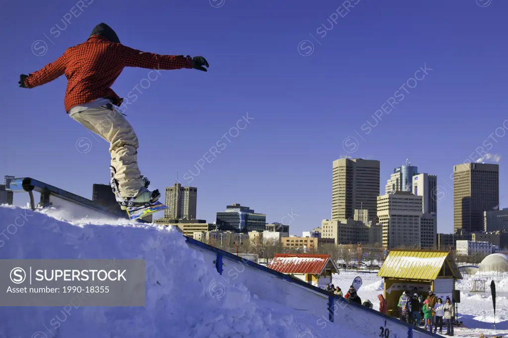 Teenage male snowboarder at The Forks Winter Park in downtown Winnipeg. Part of Snowjam snowboarding competition. Winnipeg, Manitoba, Canada.