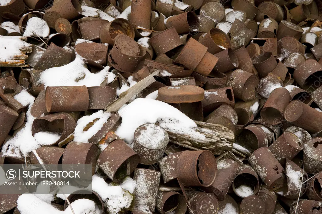 Pile of old rusting tin cans and fresh snow