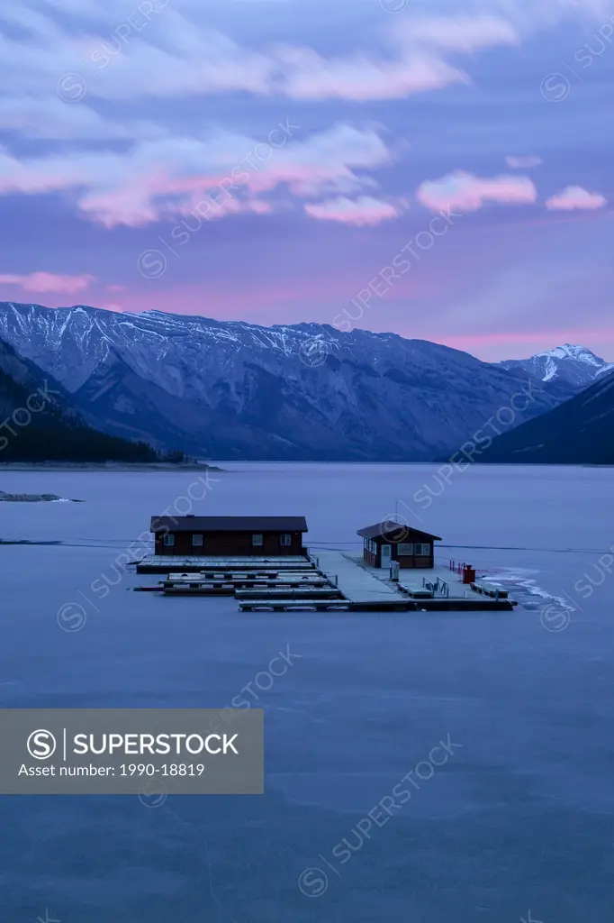 Floating dock on frozen Lake Minnewanka at sunrise, Banff National Park, Canada