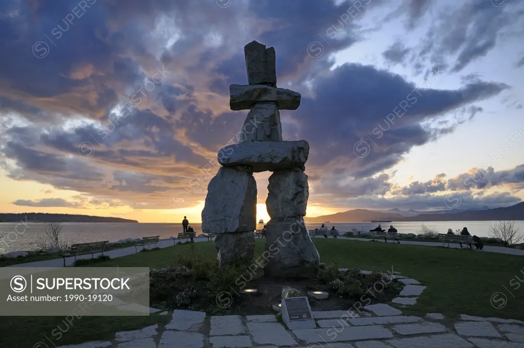 Inuit sculpture, Inukshuk, with dramatic cloud backdrop, English Bay, Vancouver, British Columbia, Canada