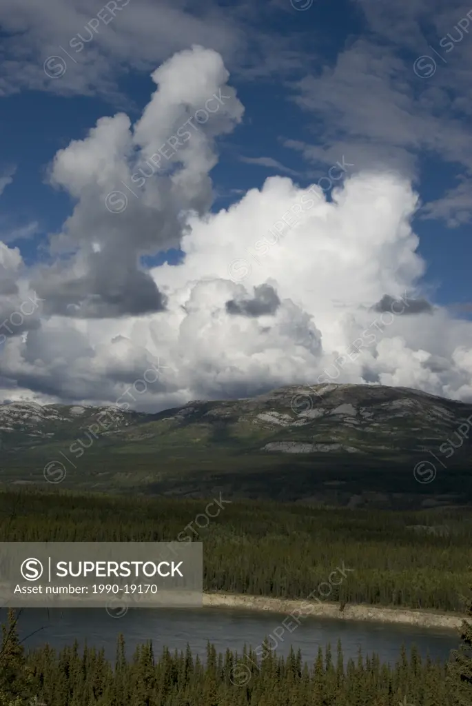 Yukon River near Grey Mountain, with cumulus clouds forming in distance. Yukon Territory, Canada