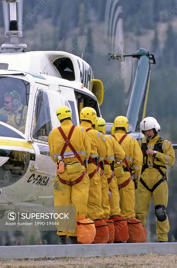 A forest firefighting crew preparing to board a helicopter for transportation to a forest fire.