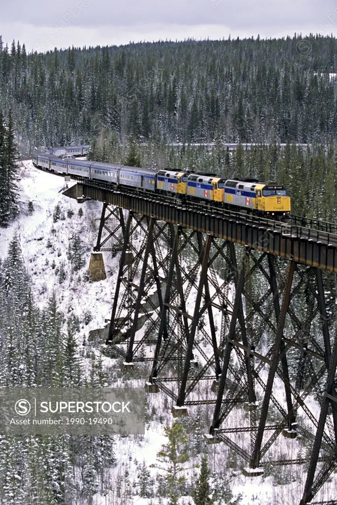 Via Rail passenger train crossing a wooden tressel on a winters day in northern Alberta Canada.