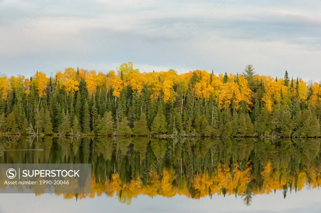 Sunset skies over small Canadian Shield Lake, with autumn aspens