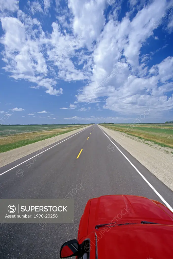 road going across the prairies with pick_uptruck in the foreground, near Culross, Manitoba, Canada