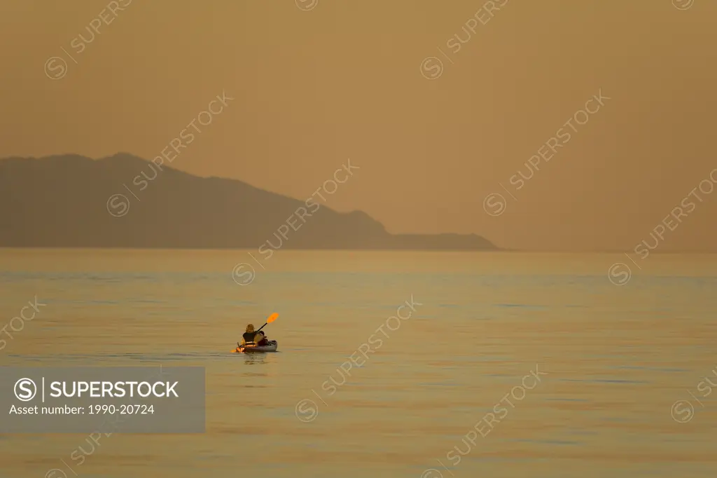 A mother and child at twilight, kayak into the peaceful waters of Georgia Strait just off of Goose Spit Regional Park. Comox, The Comox Valley, Vancou...