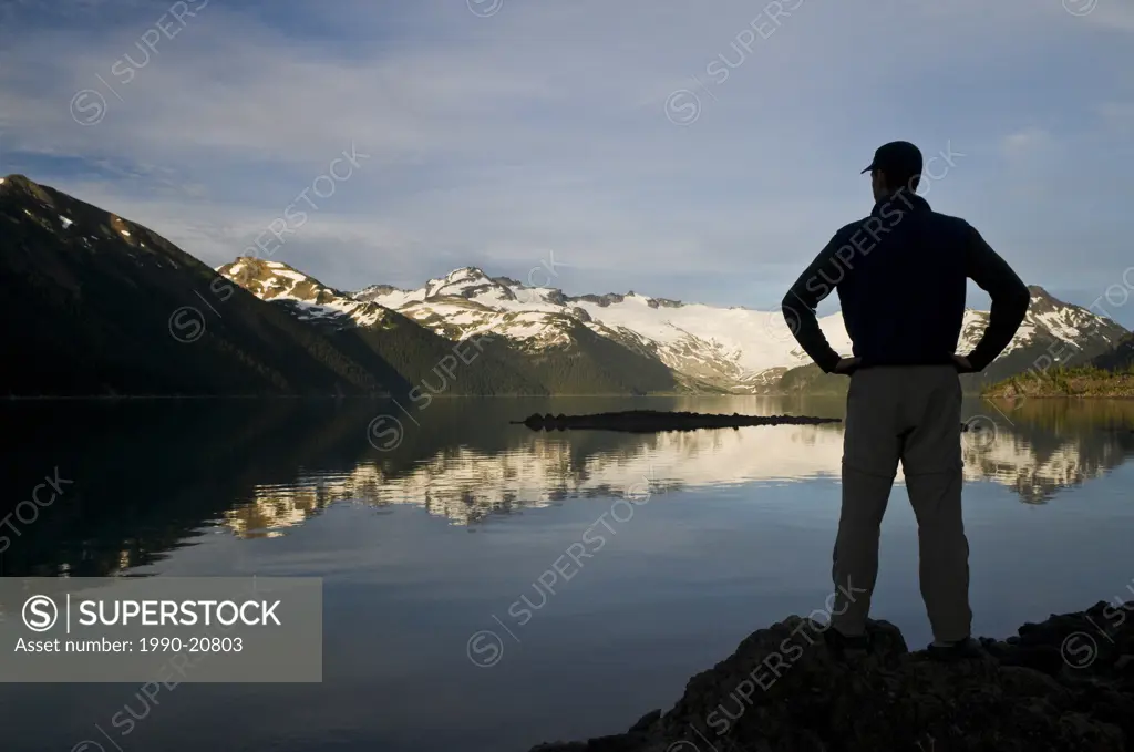 A hiker is silhouetted by the Sphinx Glacier at Garibaldi Lake in Garibaldi Provincial Park near Whistler BC.