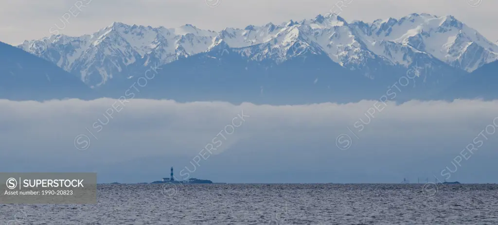 Race Rocks lighthouse and the Olympic Mountains seen from Witty´s Lagoon Regional Park in Metchosin, near Victoria BC