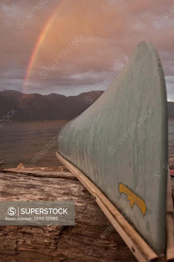 After the strom cleard a rainbow is visable behind the parked canoe on Columbia Lake , Creston B.C