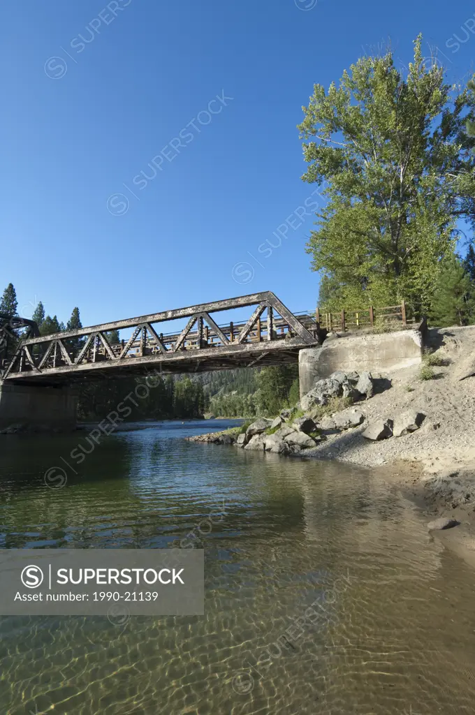 Boy jumping from trestle bridge at Kettle River Provincial Park, BC, Canada