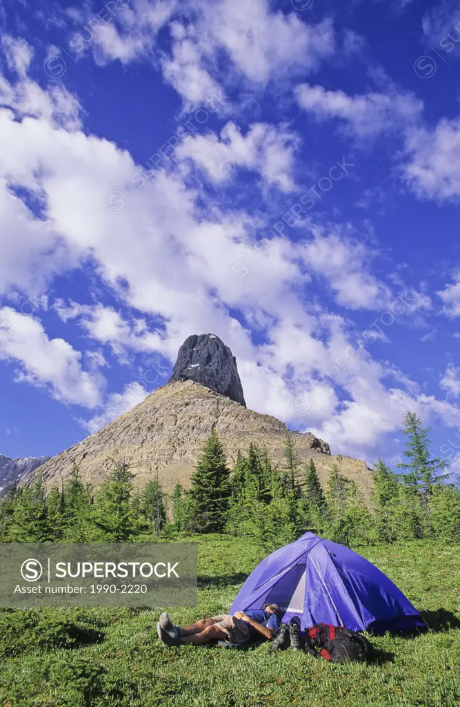 Backpacker napping outside his tent, Rockwall Trail, Kootenay National Park, British Columbia, Canada