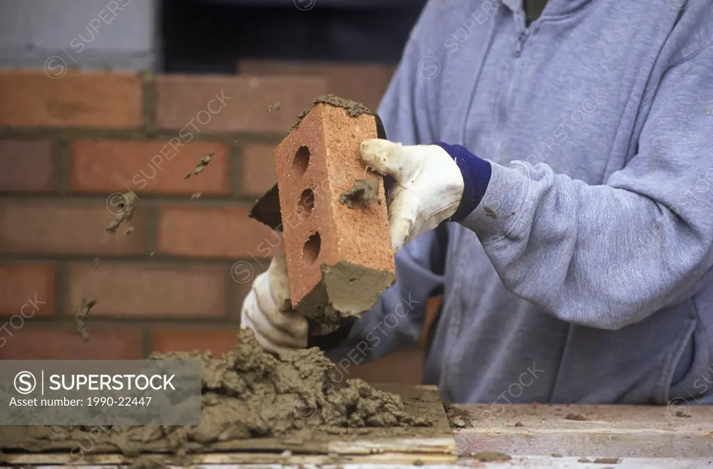 Construction work  Bricklayer applies mortar while constructing brick wall, British Columbia, Canada