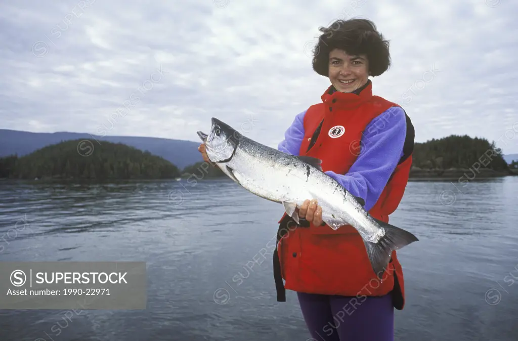 ocean fishing, female angler displays coho salmon catch, Vancouver Island, British Columbia, Canada