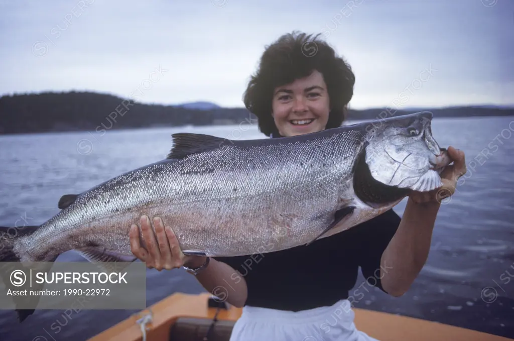 Ocean fishing, female angler displays chinook salmon catch, Vancouver Island, British Columbia, Canada