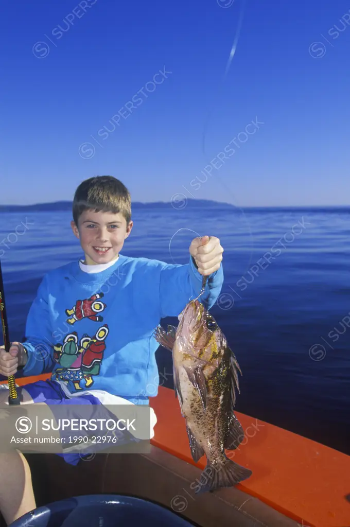 Ocean fishing, boy displays rockfish catch, Vancouver Island, British Columbia, Canada