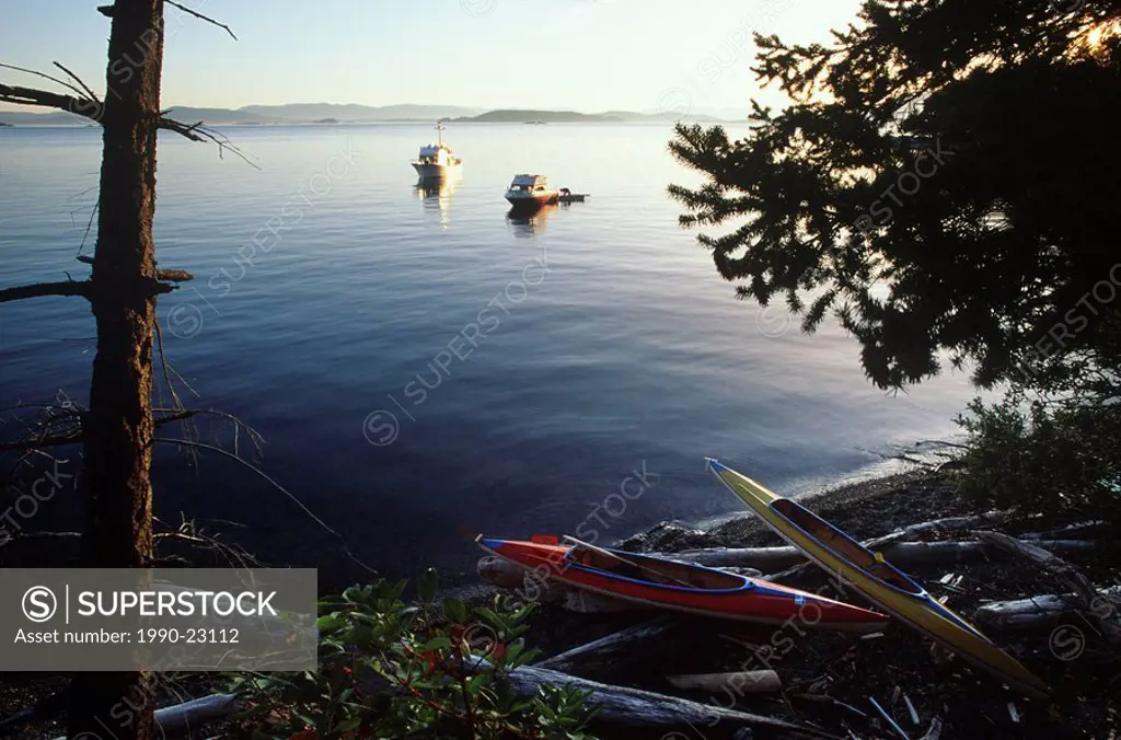 Gulf Islands ocean kayaks on beach, yachts anchored, Vancouver Island, British Columbia, Canada