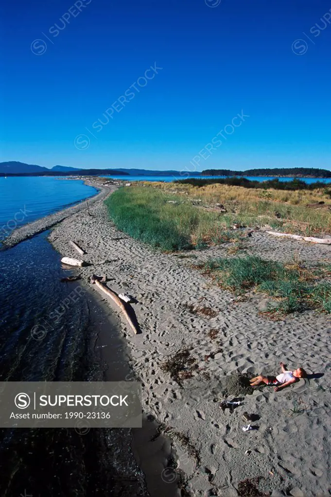 Sidney Spit , Gulf Islands National Park, boy plays on beach, British Columbia, Canada