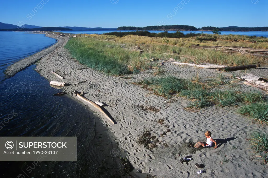 Sidney Spit , Gulf Islands National Park, boy plays on beach, British Columbia, Canada