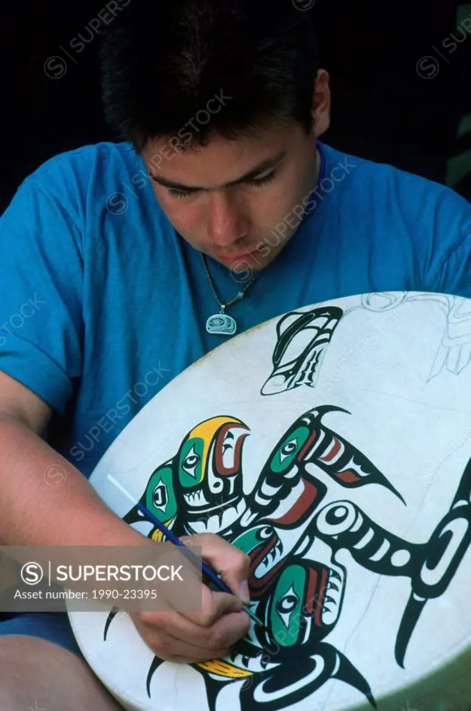First Nations man paints drum in Kwakwaka´wakw Kwakiutl tradition, Vancouver Island, British Columbia, Canada