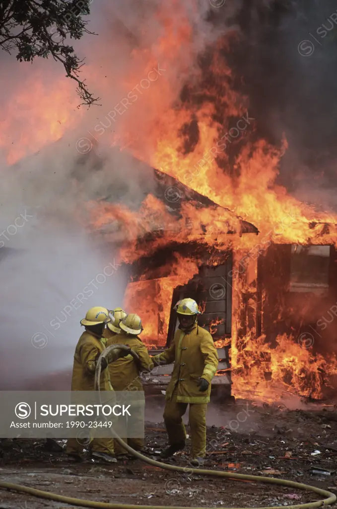 Firemen douse burning building, British Columbia, Canada