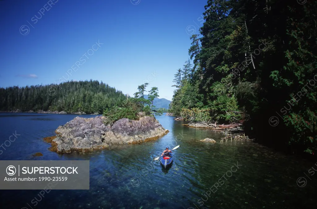 Nootka Sound, kayaker paddles off Bligh Island, Vancouver Island, British Columbia, Canada