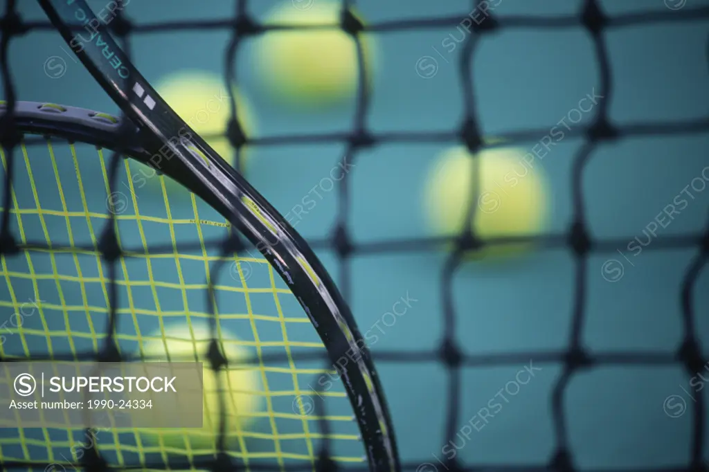Sport - tennis racquet and balls by net after practice, British Columbia, Canada
