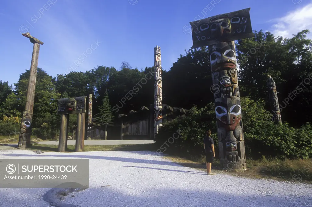 Boy looks at Totem poles on the grounds of the University of British Columbia Museum of Anthropology, British Columbia, Canada