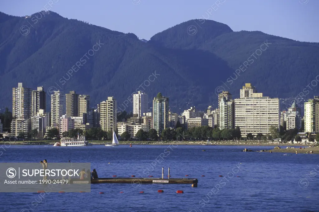 Kids play on a dock in English Bay along Kitsilano Beach, downtown Vancouver beyond, Vancouver, British Columbia, Canada