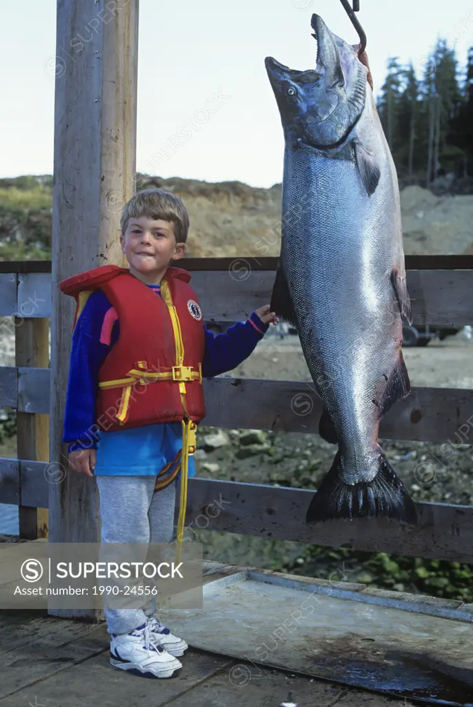 Six year old boy and 50 lb chinook salmon, Telegraph Cove, British Columbia, Canada
