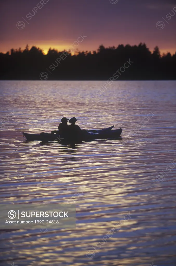Madrona Point, sea kayakers at dusk, Craig Bay, Parksville area, Vancouver Island, British Columbia, Canada