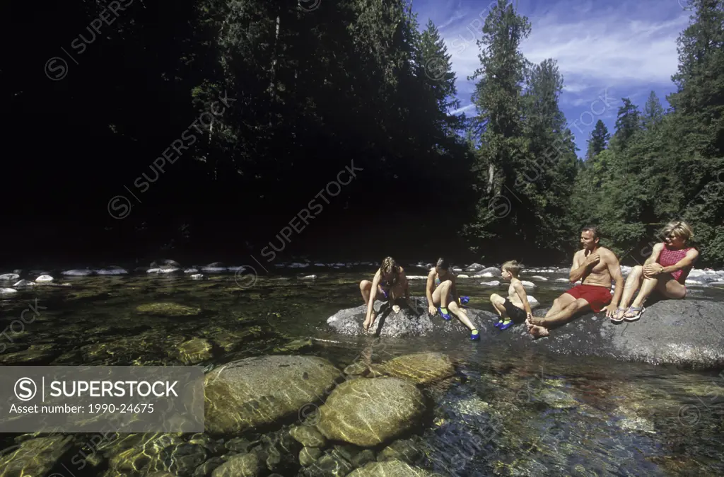 Englishman River Provincial Park  Family swimming and sunning on rocks in river, British Columbia, Canada