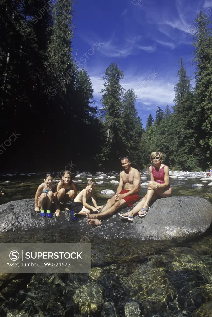 Englishman River Provincial Park  Family swimming and sunning on rocks in river, British Columbia, Canada