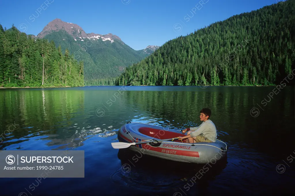 Schoen Lake , boy paddling dingy, Vancouver Island, British Columbia, Canada