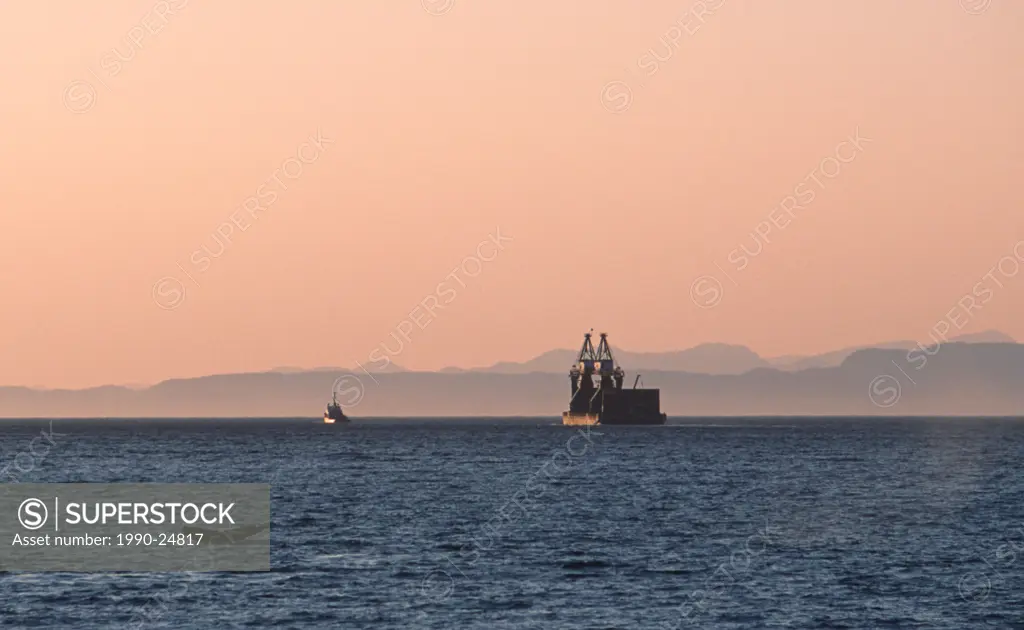 Johnstone Strait humpback whale tail with towbat and barge beyond, Vancouver Island, British Columbia, Canada