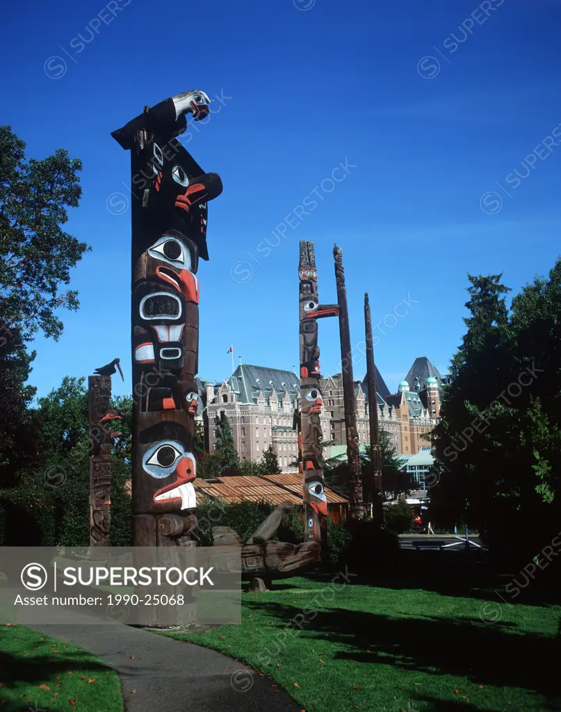 Totem poles at Thunderbird Park stand before Empress Hotel, Victoria, Vancouver Island, British Columbia, Canada